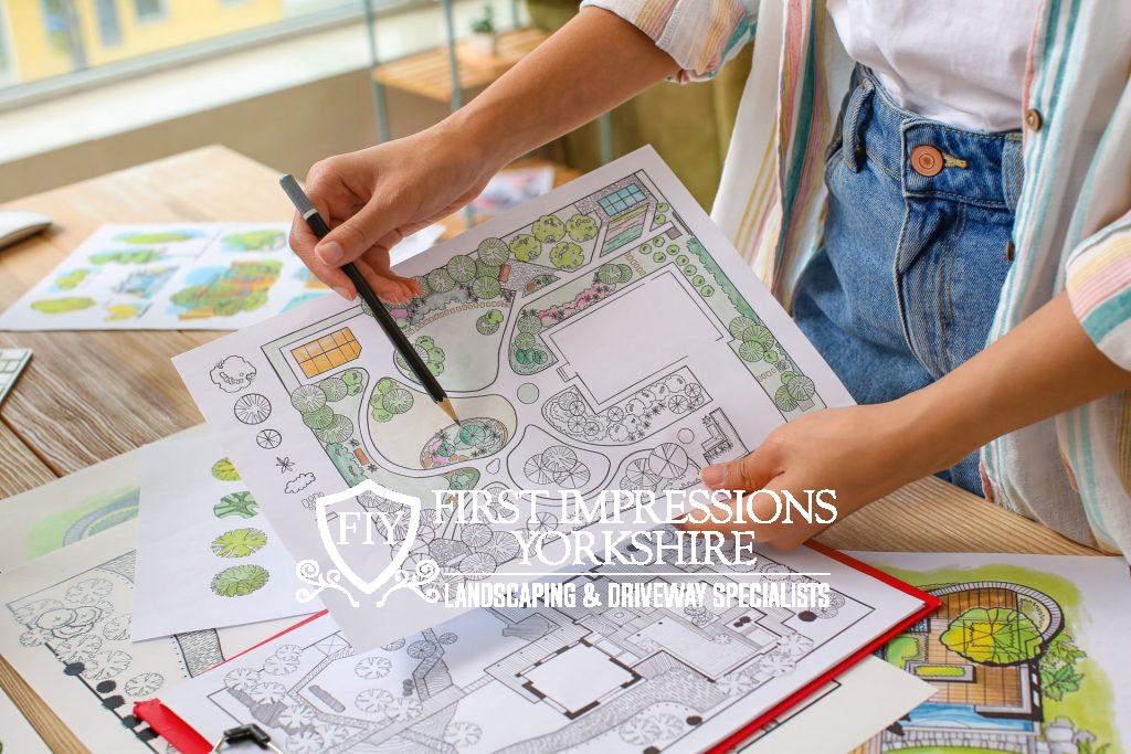 Person assessing garden plan drawings