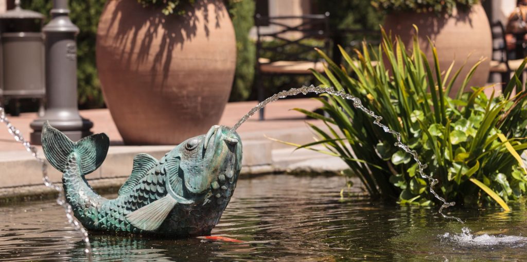 Fish ornament with water fountain coming from mouth into the fish pond