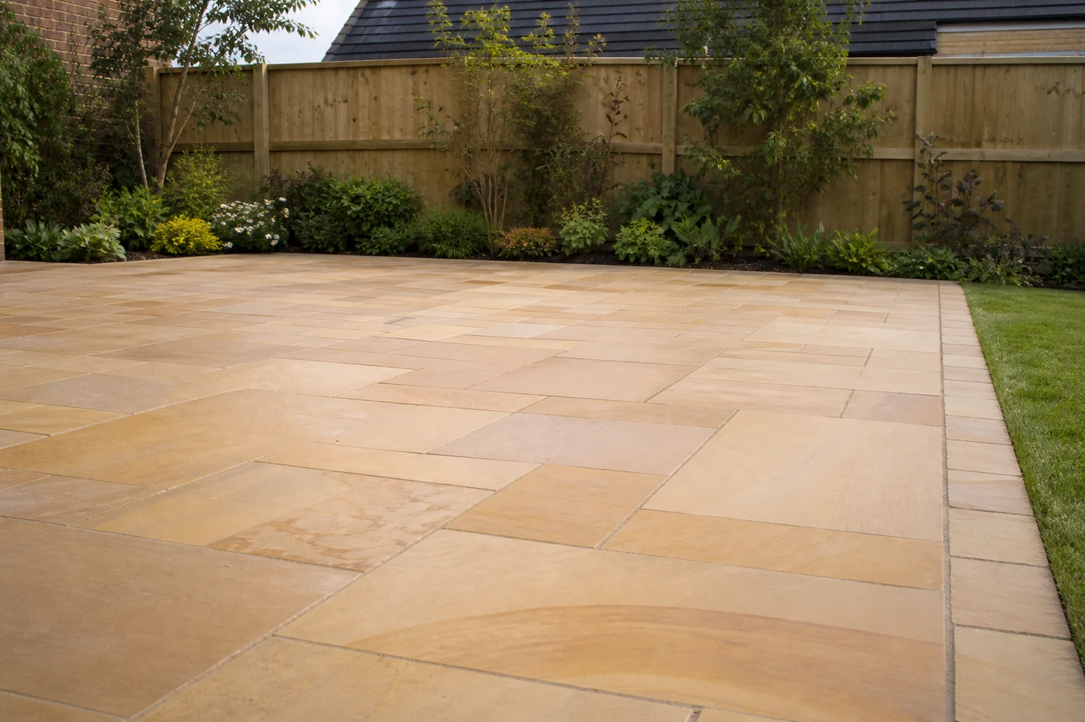 Level finished Indian stone patio with crisp border edging